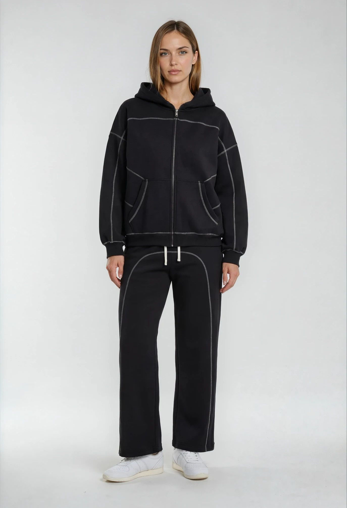 A girl wearing a black hoodie and sweatpants.