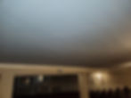 A wide dark ceiling hangs above empty theater seating, viewed from beneath a beam