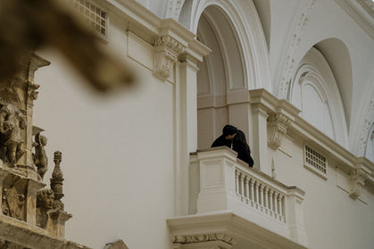 Margarita and Raphael share a kiss on a grand museum balcony, captured by London engagement photographer Keidi Vaikma.