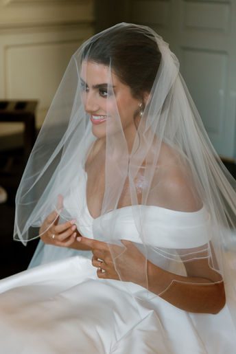 Elegant bridal portrait of a smiling bride in an off-the-shoulder gown and veil, beautifully captured by London wedding photographer Keidi Vaikma, specialising in timeless wedding photography.