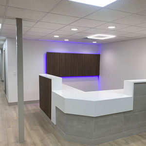 Pediatric office interior modern style with white counter tops, wood flooring, gray slate and striped wood facade