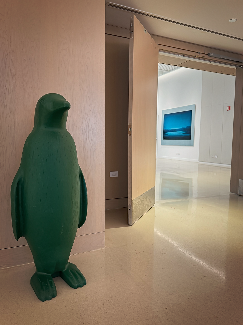 Green penguin stands in museum.