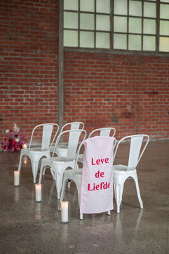 Witte stoelen, 'Leve de Liefde' banner, trouwceremonie