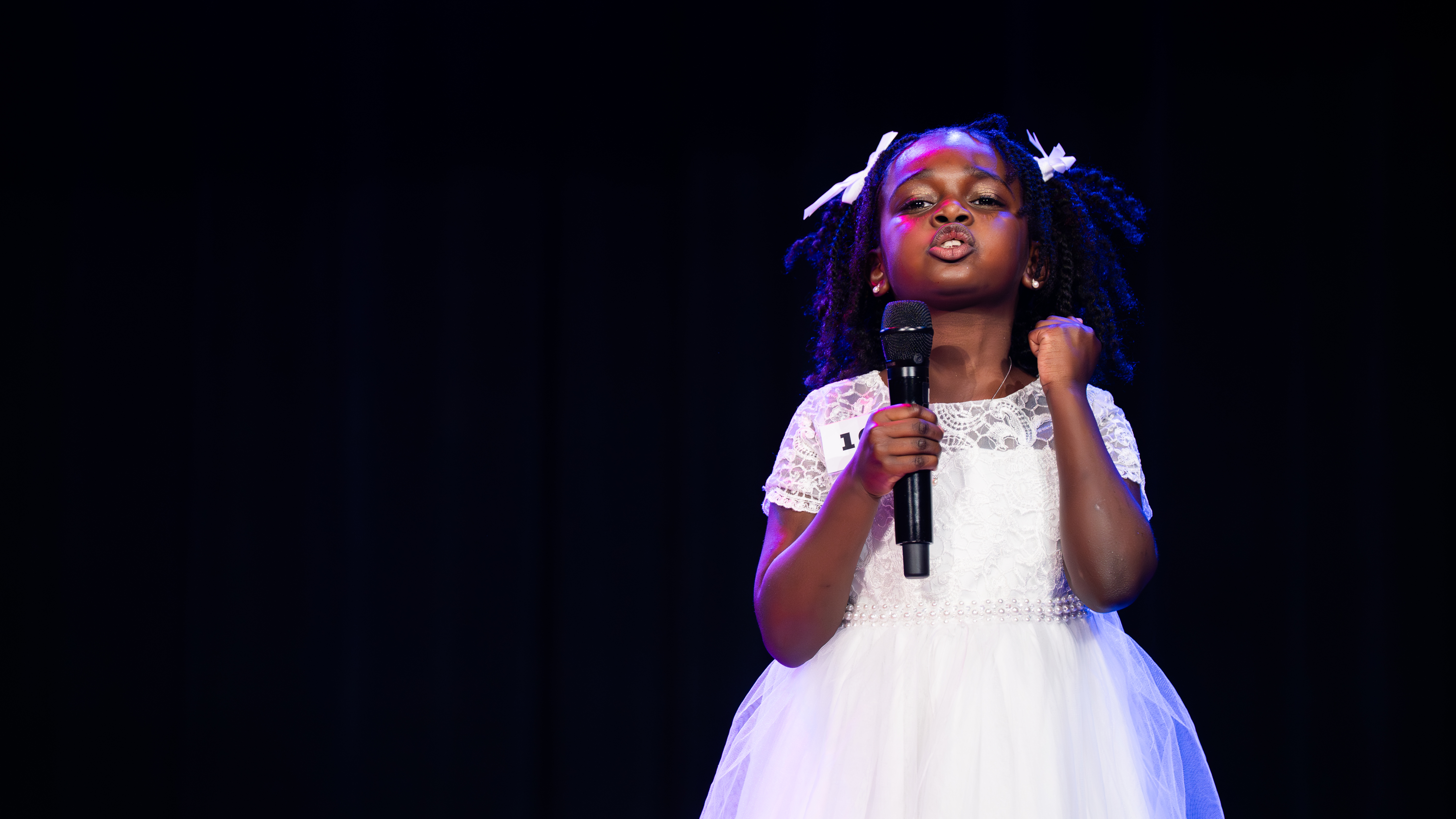 Asmara speaking into the microphone at the pageant.