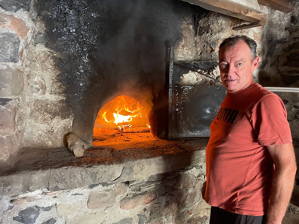 Un villageois en charge de démarrer le feu du four à pain communal pour la fête patronale