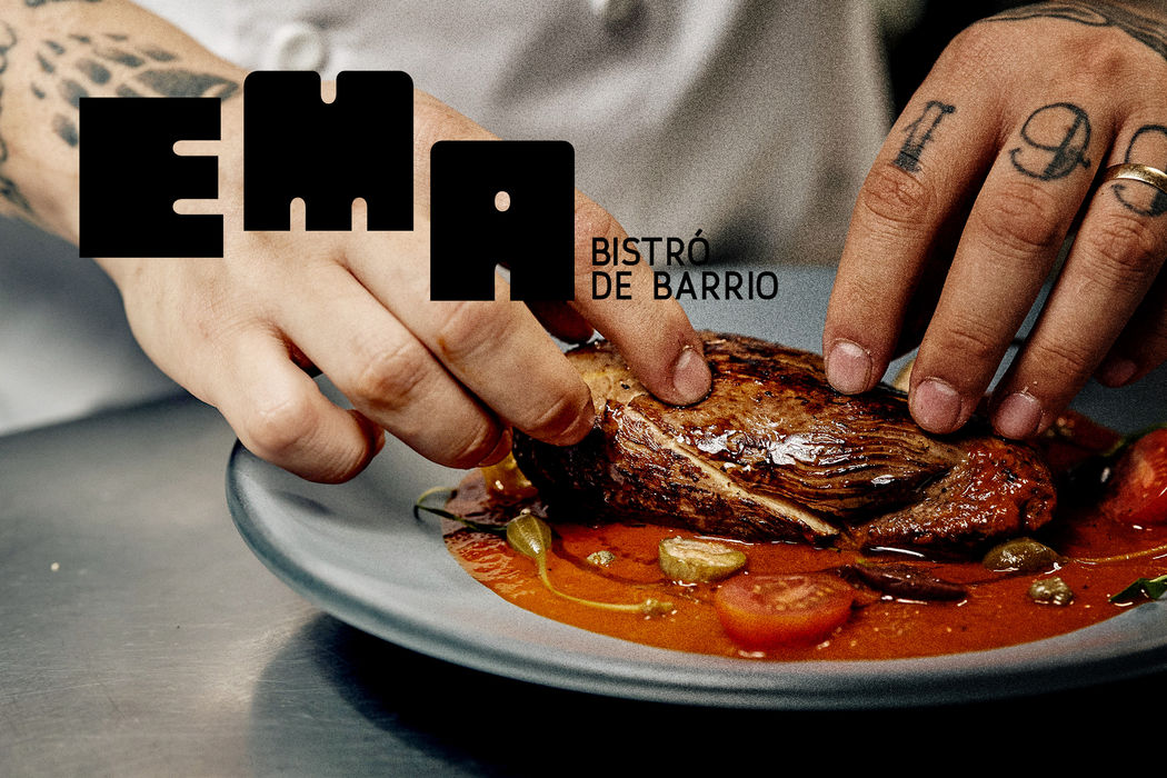 Logo EMA sobre plato de carne, fotografía de menú del restaurante