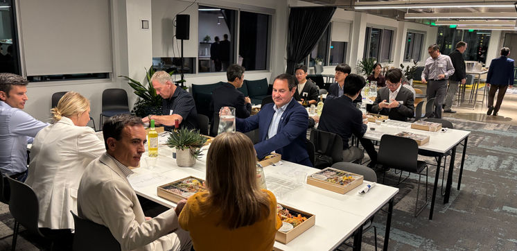 People casually sitting around tables eating and talking