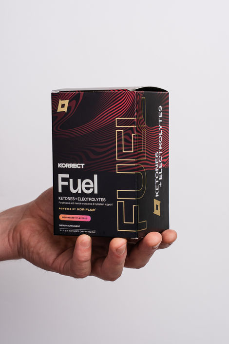 a hand is holding a box of Korrect fuel ketones + electrolytes