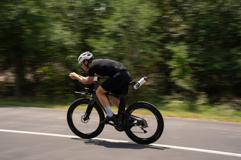 a man wearing a helmet is riding a bike down a road
