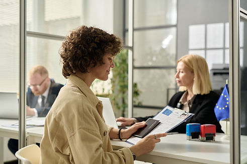 Side view portrait of smiling young woman holding approved visa application form in immigr