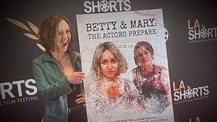 Dana Lyn Baron on the red carpet with the film poster for Betty & Mary: The Actors Prepare