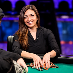 Kelly Minkin smiling at a poker table with stacks of chips during a live tournament.
