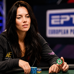 Liv Boeree playing poker at a tournament table with stacks of chips in front of her.