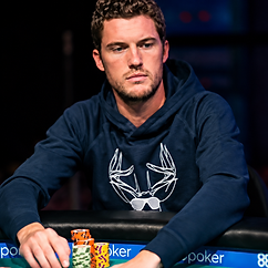 Thomas Boivin seated at a poker table in a navy hoodie, with stacks of tournament chips in front of him.