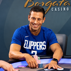 Garrett Adelstein seated at a poker table with stacks of chips during a high-stakes cash game.
