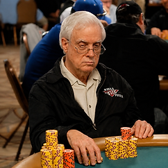 Berry Johnston seated at a poker table with stacks of tournament chips during live poker play.