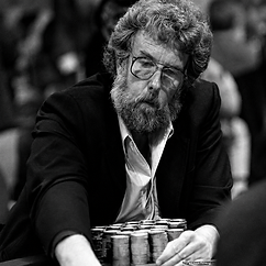 Jack “Treetop” Straus seated at a poker table behind stacks of chips in a black-and-white portrait.