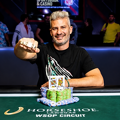 Nacho Barbero smiling at a poker table while displaying a championship ring, with poker chips and playing cards in front of him at Horseshoe Las Vegas.