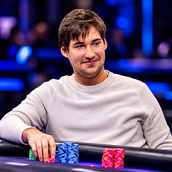 Alex Anton seated at a poker table with stacks of colorful tournament chips during a live poker event.
