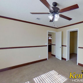 Bedroom interior with ceiling fan and KenCo Homes logo in the corner.