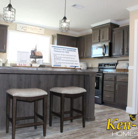 Interior kitchen view with Ken-Co Homes Inc. sign and two bar stools