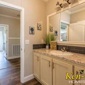 Bathroom interior with mirror, cabinet, and Ken-Co Homes text