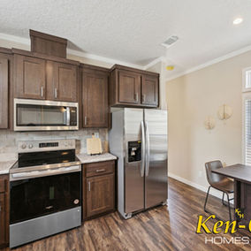 Modern kitchen with Ken-Co. Homes cabinets, appliances, and dining area.