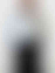 A black and white jersey V-neck tunic with a loose fit, V-neckline, and long sleeves. Made from a cotton-polyester blend