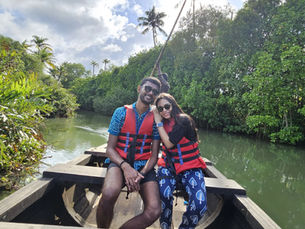 Luisa and Aswin sitting on a small boat in the backwaters of Kerala