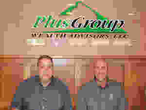 Jay Lauer and Brent Neis by new Plus Group Wealth Advisors Sign.