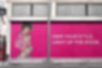 Bold outdoor billboard with a woman in a vibrant pink outfit holding a skateboard, featuring the empowering slogan "Own your style, light up the room," promoting self-expression and streetwear fashion.
