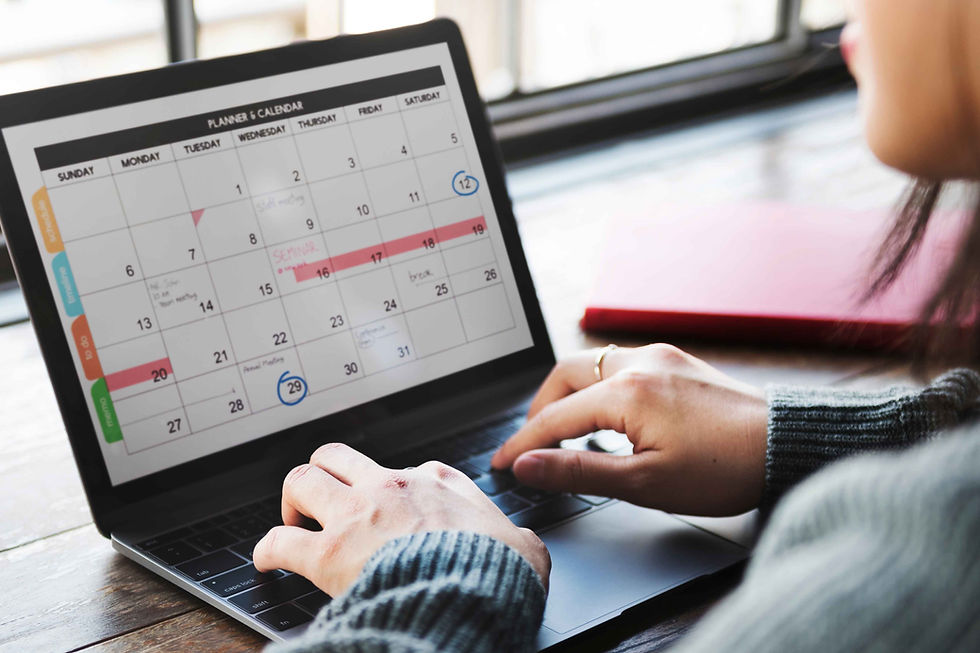 Person working on a laptop with a digital content calendar open.