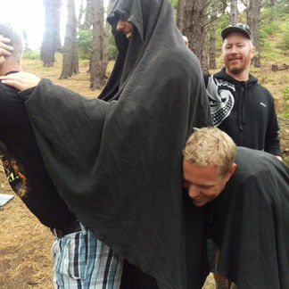 Three men recreating the horse and rider scene in Lord of the Rings
