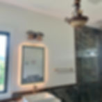Bathroom lighting by Bradford Electric LLC with backlit mirror.