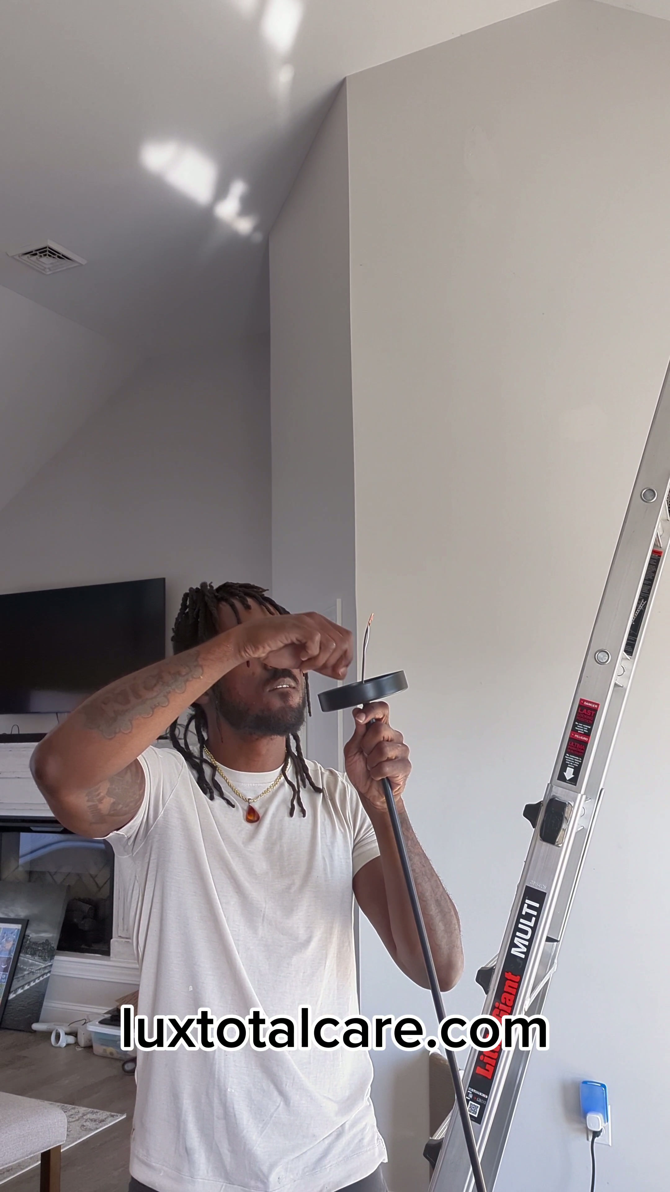 Lux Total Care installing a light fixture in a commercial space