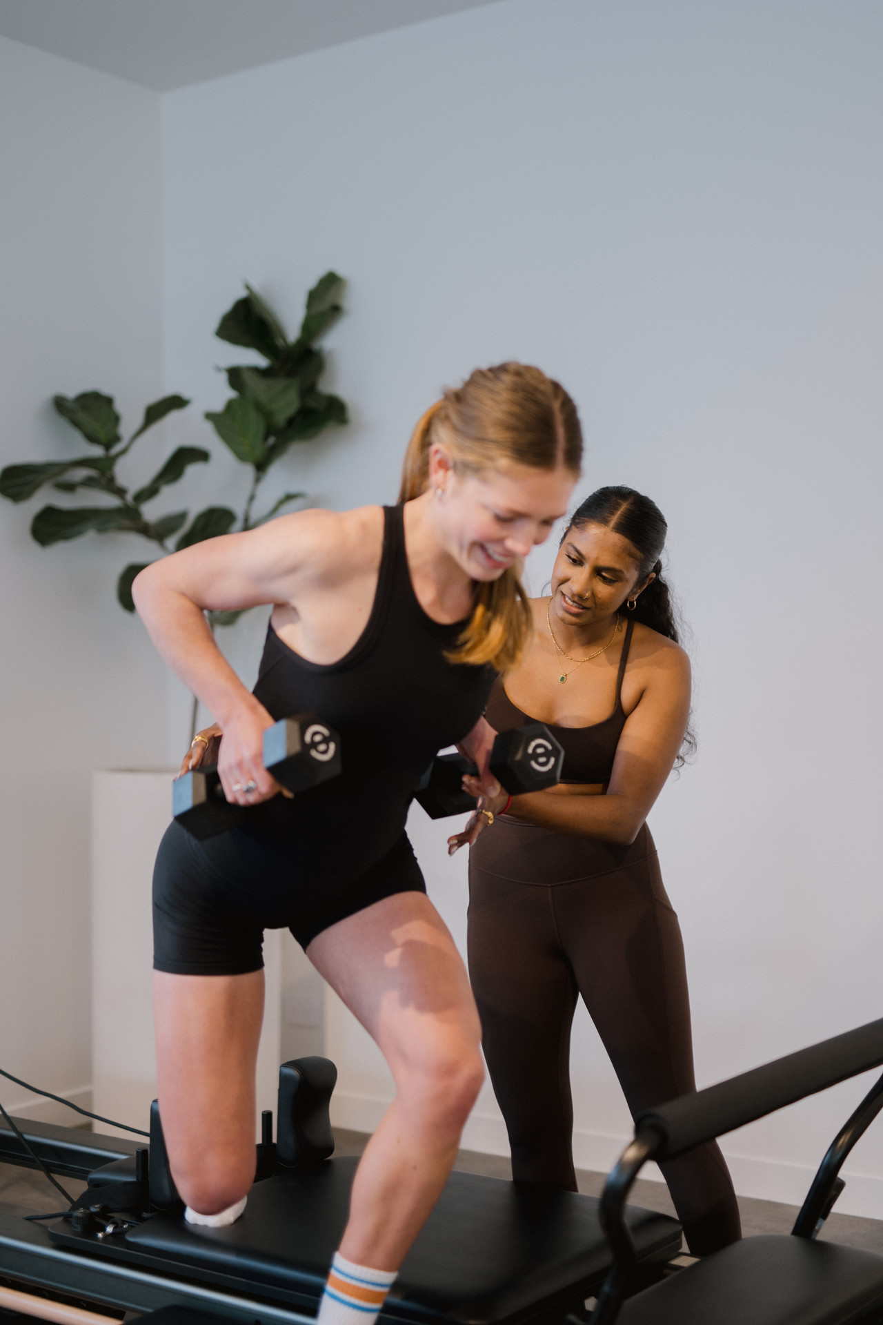 A Reform instructor coaching a client through a movement on the reformer