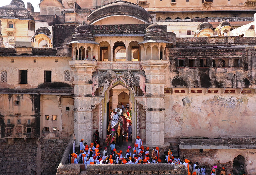 The procession emerges through the massive elephant gate of the Garh