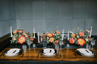 vibrant floral centrepieces on table with black and white accents