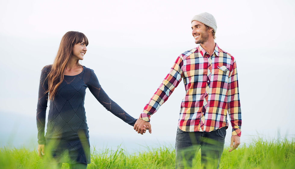 Ein Paar hält sich an den Händen und schaut sich lächelnd an – Symbol für Verbindung, Liebe und das Loslassen ohne Trennung.