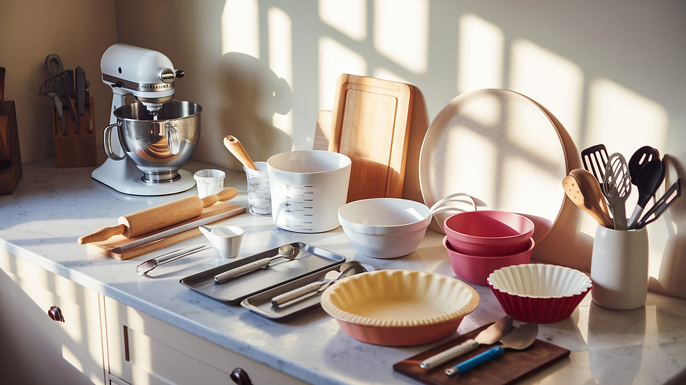 Sunny kitchen counter with a mixer, cutting boards, bowls, and baking tools. Warm light casts shadows, creating a peaceful, prepared vibe.