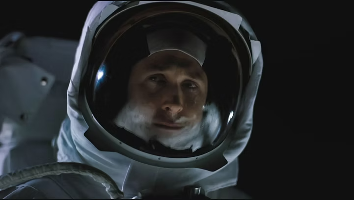 Ryan Gosling em close dramático usando traje espacial branco em "Devoradores de Estrelas" (2025), encarando o vazio do espaço com expressão séria e contemplativa.