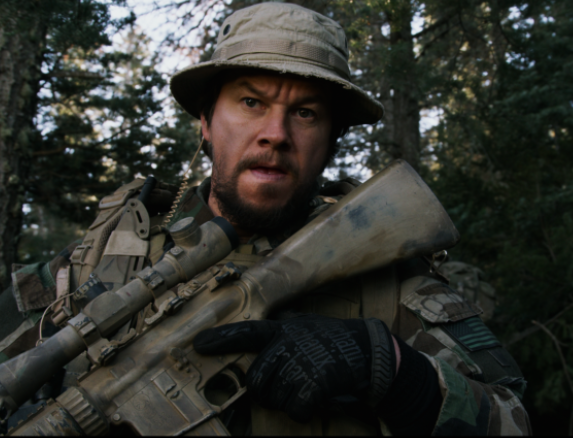 Mark Wahlberg como Marcus Luttrell armado e em alerta na floresta durante missão dos Navy SEALs no filme O Grande Herói (2013