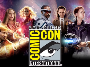 Logo oficial da San Diego Comic-Con International em destaque sobre montagem com heróis da Marvel, incluindo Pantera Negra, Feiticeira Escarlate, Capitã Marvel, Falcão, Loki, Viúva Negra, Thor, Shuri e Shang-Chi, com fundo cósmico.