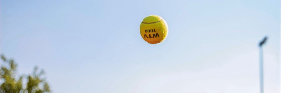 Tennisball mit "SPAL ALM"-Logo im Flug