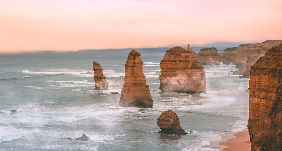 Iconic view of the Twelve Apostles rock formations along the Great Ocean Road in Australia, surrounded by crashing waves and a golden sunrise, showcasing the country’s dramatic coastal scenery.