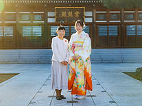 寺院の境内で成人式の記念撮影をする母娘