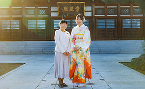 寺院の境内で記念撮影をする親子
