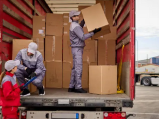 A skilled mover in Essen, booked through Co-Tasker, carefully unloading boxes from a truck. Find local professionals for your move today!