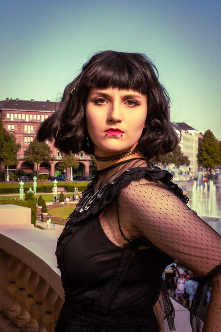 eine Cosplayerin, die als Lydia Deetz aus der Beetlejuice-Bühnenmusicalversion verkleidet ist, schaut den Betrachter mit finsterem Blick an