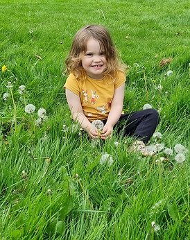 Small girl sat in the green grass